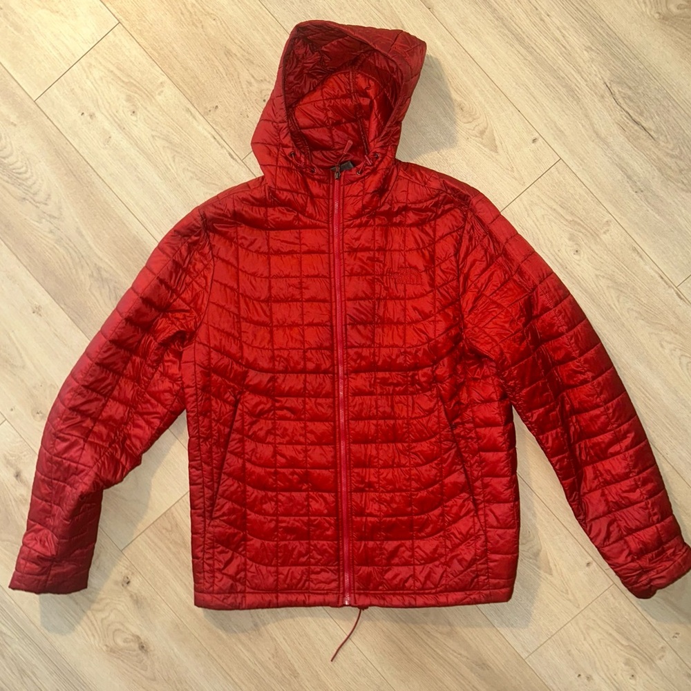 Red Northface thermoball jacket with a hood.